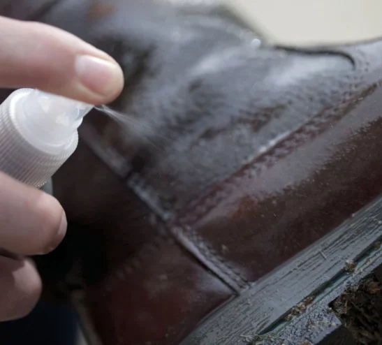 spraying-leather-conditioner-on-boot